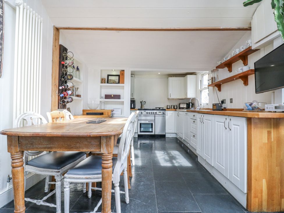 A kitchen with a dining table and appliances at 14 Marine Terrace in Whitstable