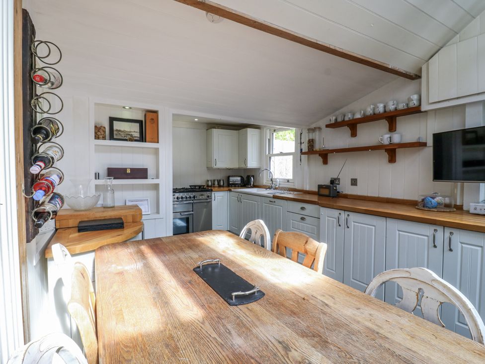 A kitchen with a dining table and appliances at 14 Marine Terrace in Whitstable
