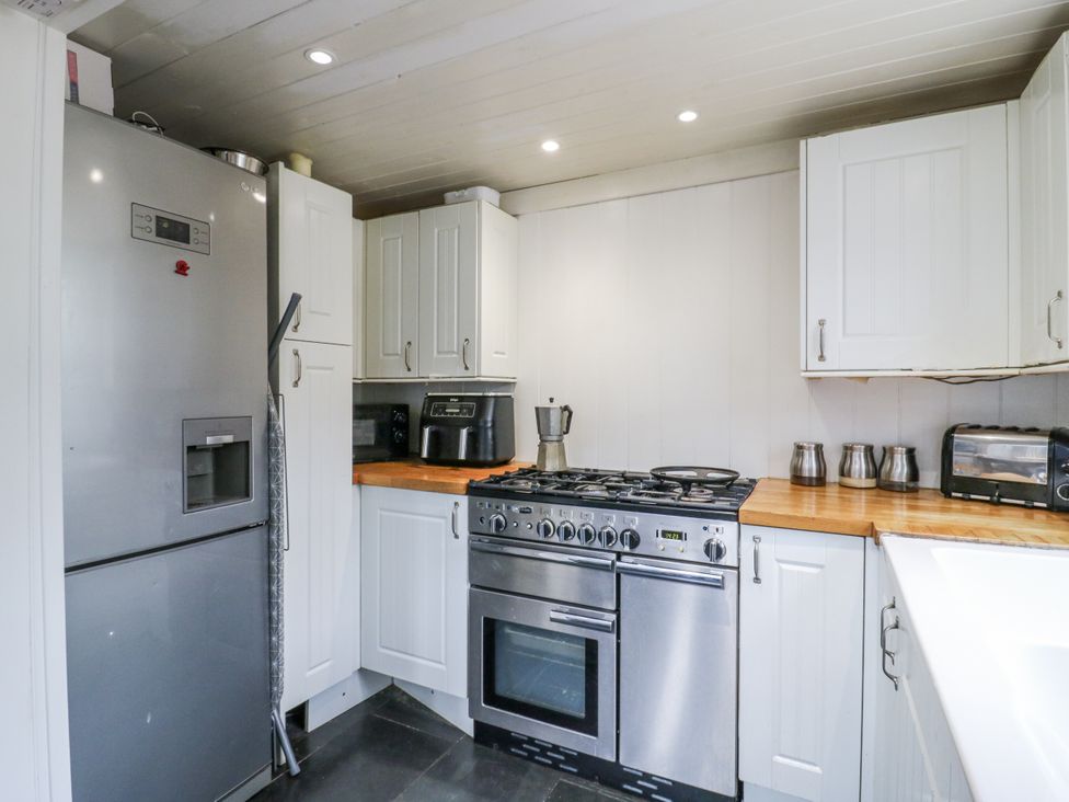 A kitchen with appliances and storage cabinets at 14 Marine Terrace in Whitstable