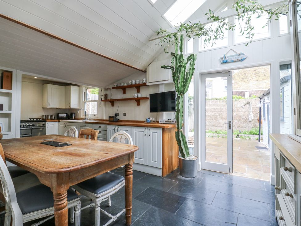 A kitchen with a dining table and cactus at 14 Marine Terrace Whitstable