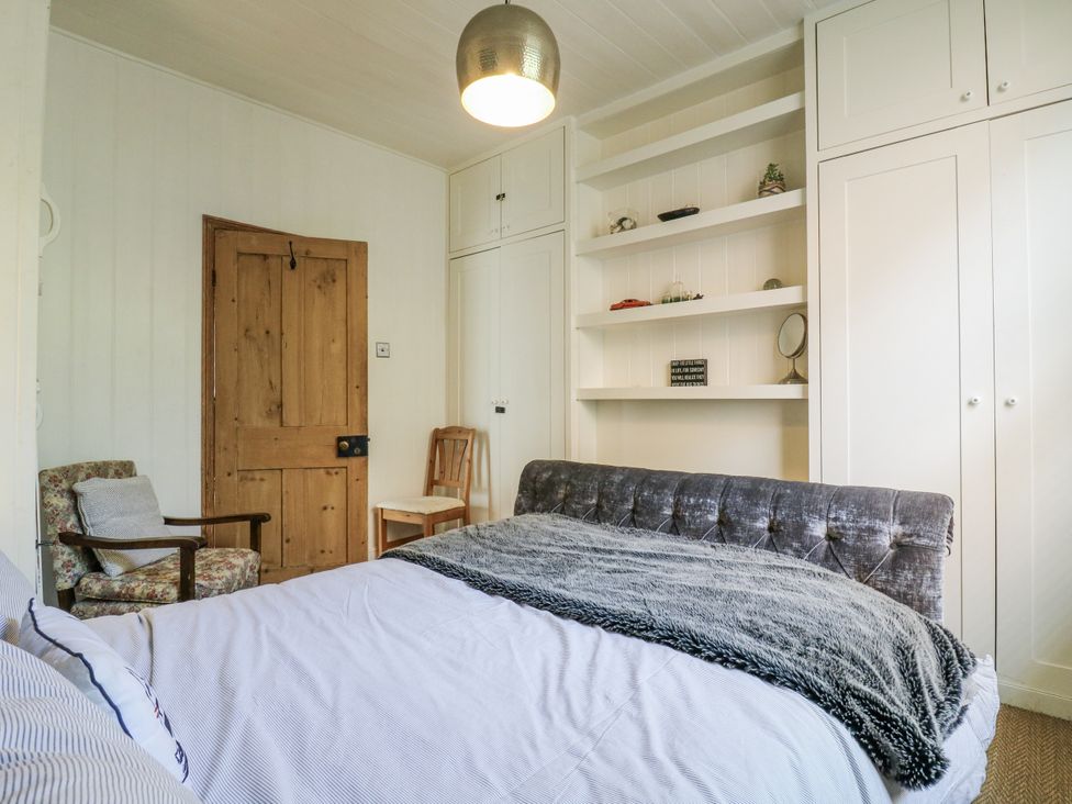 A bedroom with a bed and shelves at 14 Marine Terrace in Whitstable