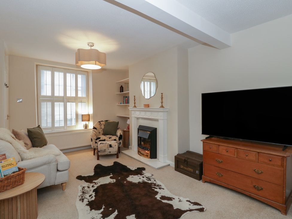 A living room with a fireplace and television at Cariad Cottage in Hereford