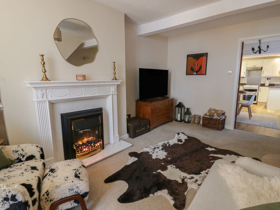 A living room with a fireplace and television at Cariad Cottage Hereford