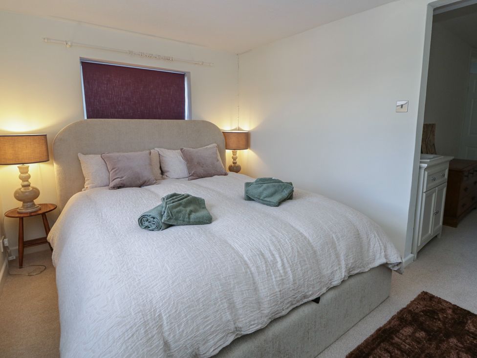 A bedroom with a bed and bedside lights at Cariad Cottage in Hereford