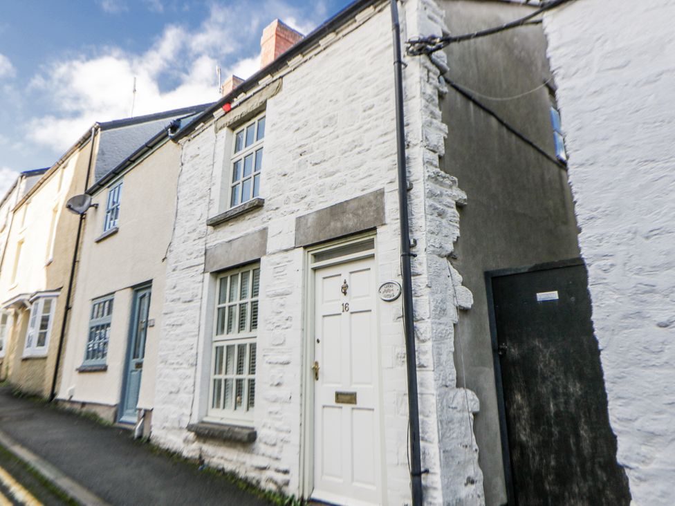 A street view of a cottage with a white door at Cariad Cottage in Hay-On-Wye