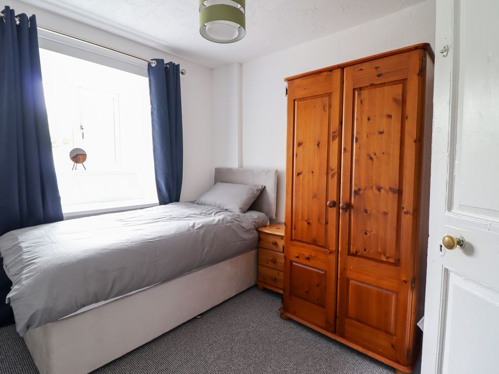 A bedroom with a bed and wardrobe at Plas Yn Bonwm in Corwen
