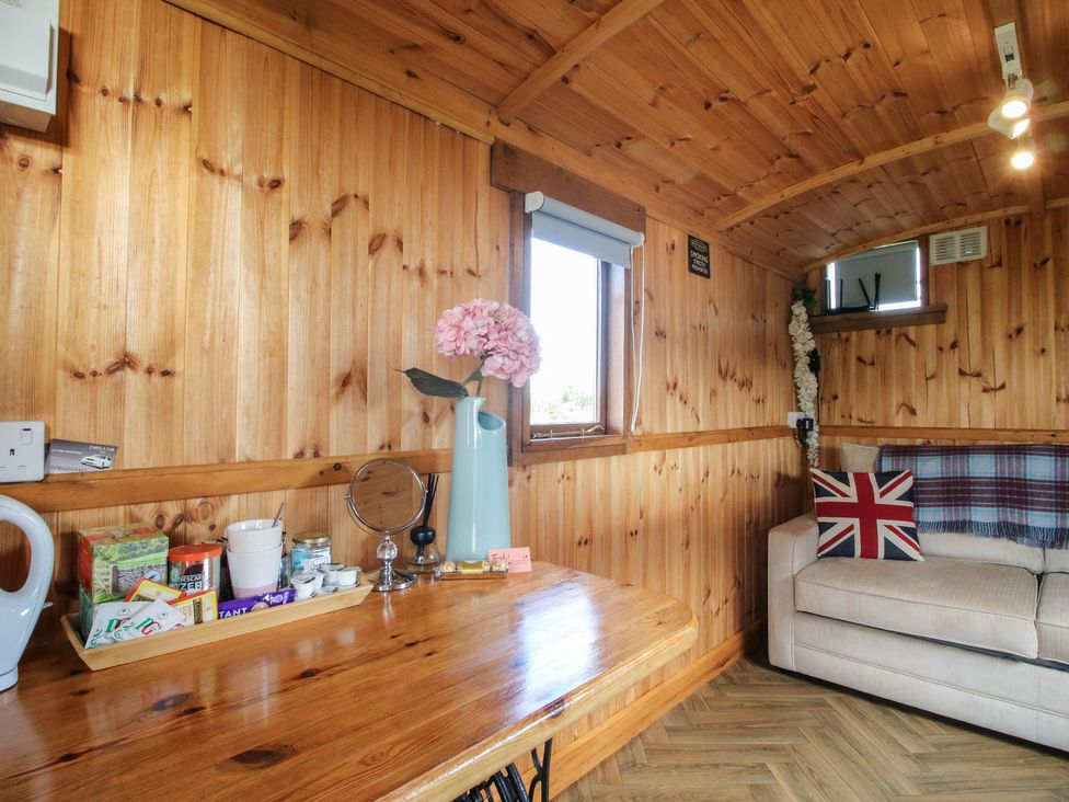 A living room with a table and sofa at Sharon's Shepherd Hut in Oswestry
