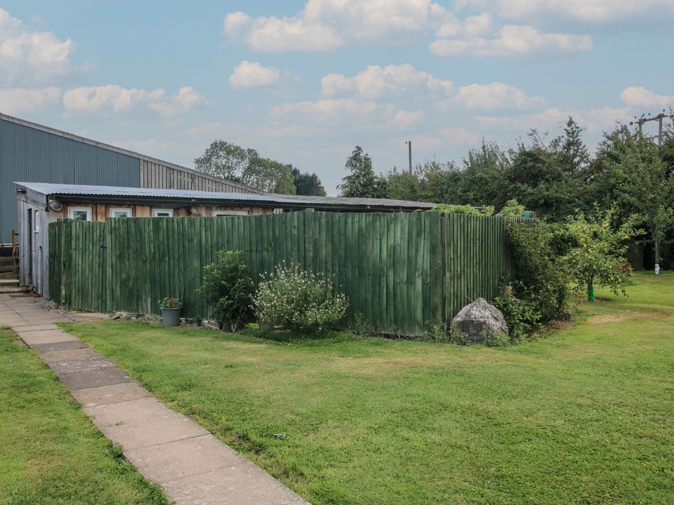 A hut surrounded by a green fence in Sharon's Shepherd Hut Oswestry