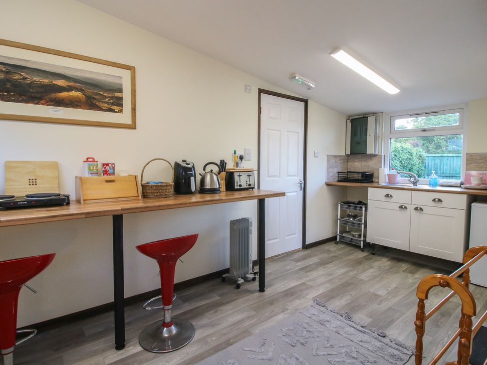 A kitchen with appliances and seating at Sharon's Shepherd Hut Oswestry