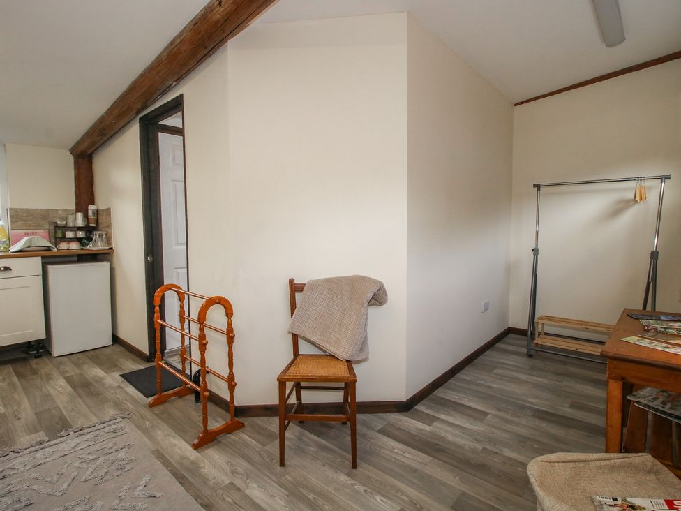 An indoor photo with a chair and a clothes rack at Sharon's Shepherd Hut in Oswestry