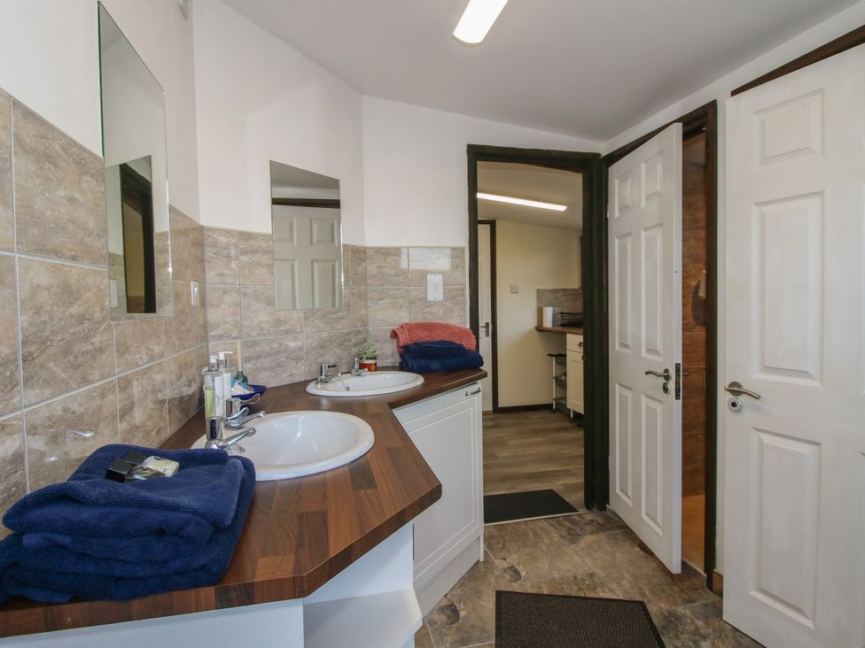 A bathroom with dual sinks and towels on the counter at Sharon's Shepherd Hut in Oswestry