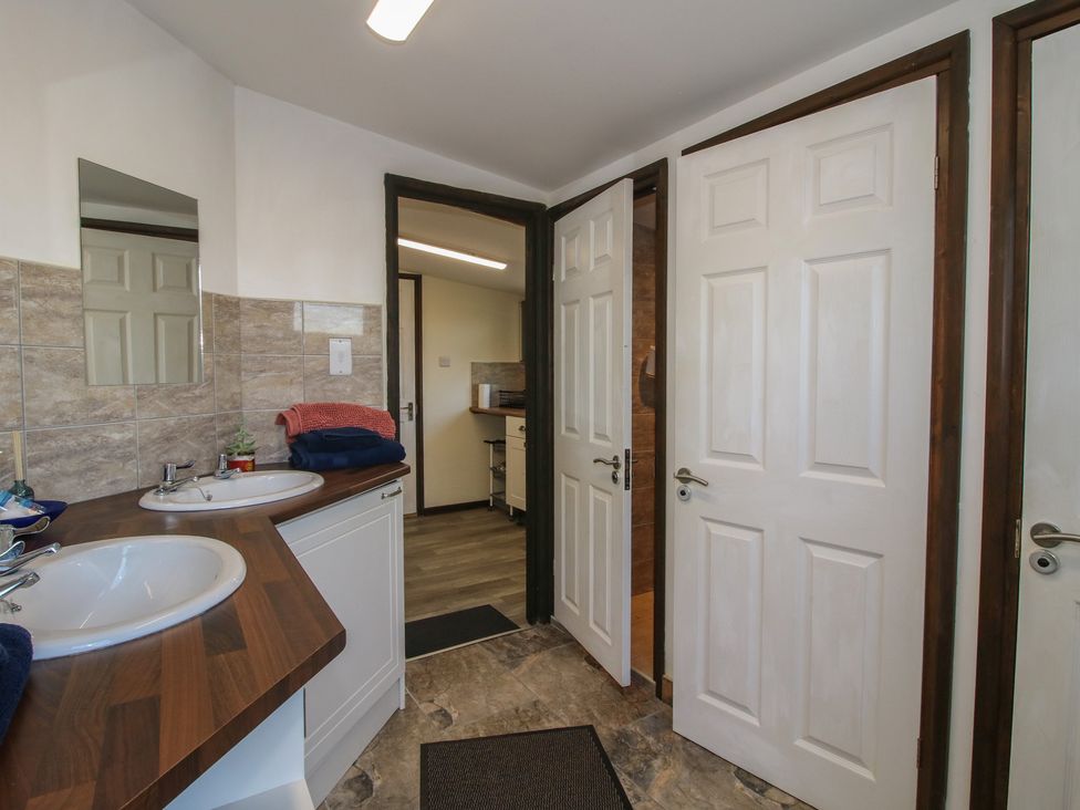 A bathroom with double sinks and a mirror at Sharon's Shepherd Hut Oswestry