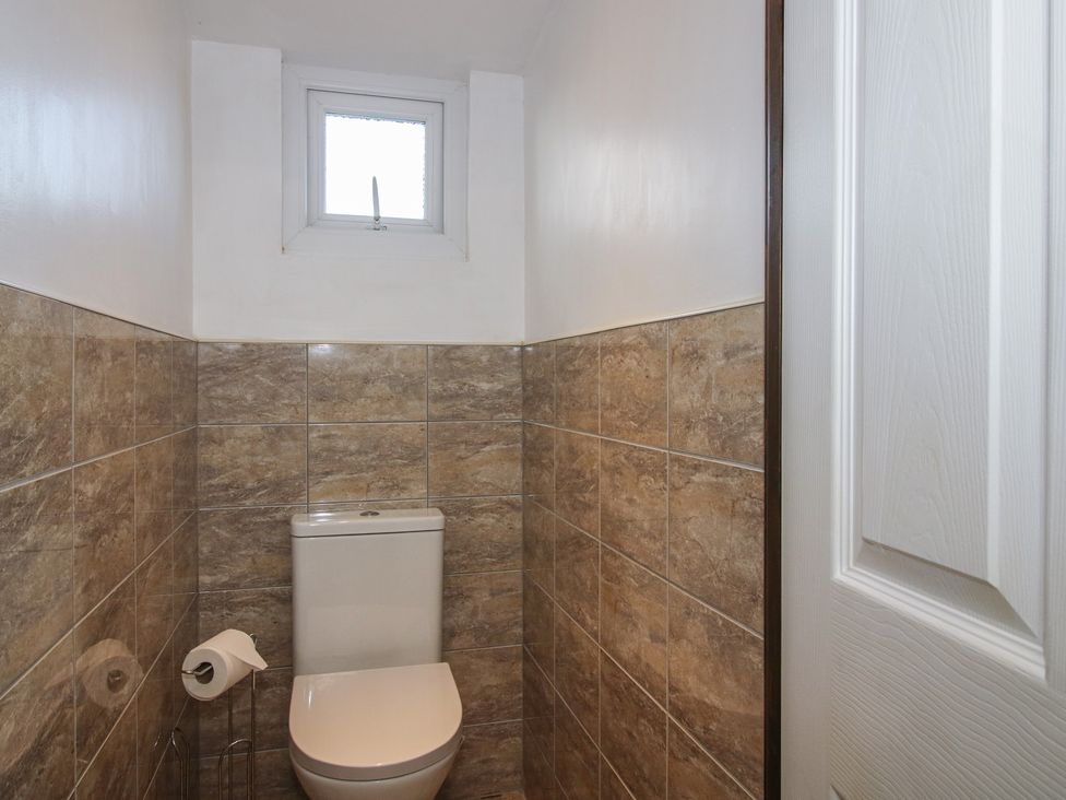 A bathroom with a toilet and window at Sharon's Shepherd Hut in Oswestry