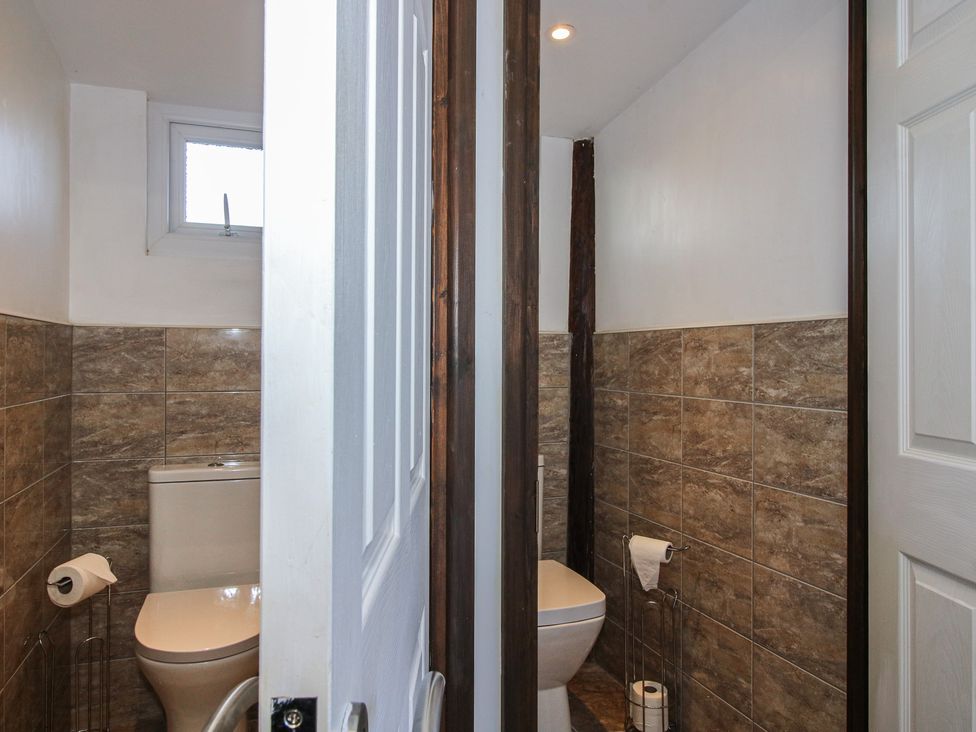 A bathroom with two toilets and a window at Sharon's Shepherd Hut in Oswestry