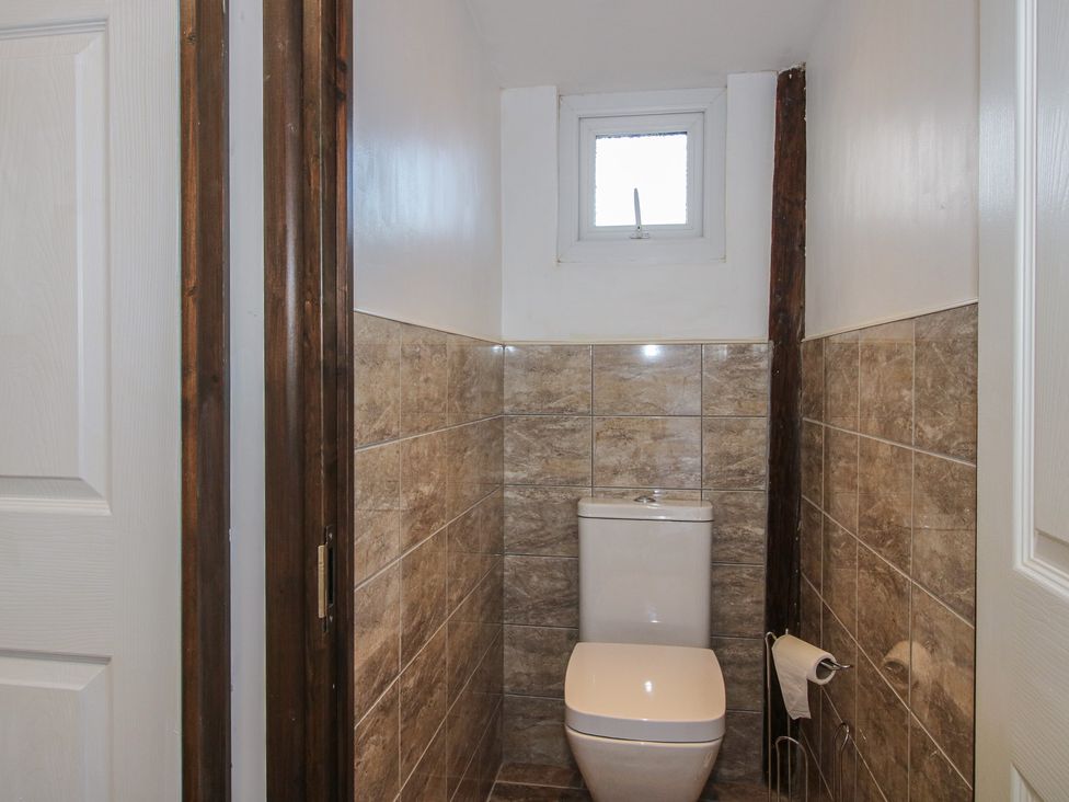 A bathroom with a toilet and window at Sharon's Shepherd Hut in Oswestry