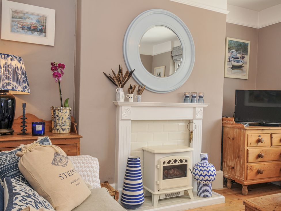 A living room with a sofa and fireplace at Mayhurst in Looe