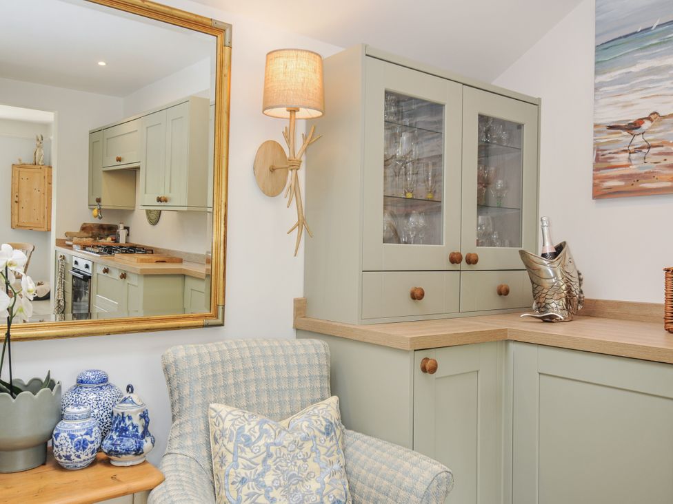 A kitchen with cabinets and a mirror at Mayhurst in Looe