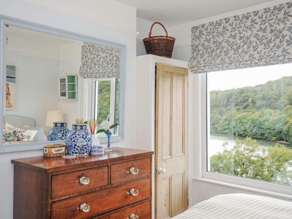 A bedroom with a dresser and window at Mayhurst in Looe