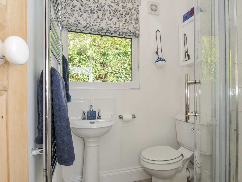 A bathroom with a sink, toilet, and shower at Mayhurst in Looe
