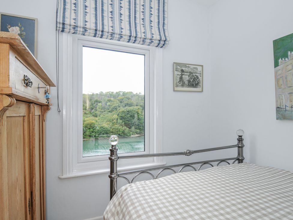 A bedroom with a bed and window at Mayhurst, Looe