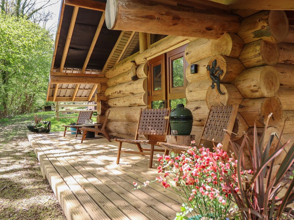 A log cabin with chairs and a planter at Owl Valley Cabin Bwlch-y-Ddar near Llanfyllin