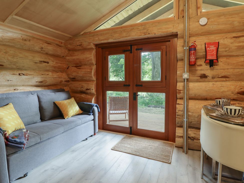 A living room with a sofa and dining table at Owl Valley Cabin Bwlch-y-Ddar near Llanfyllin