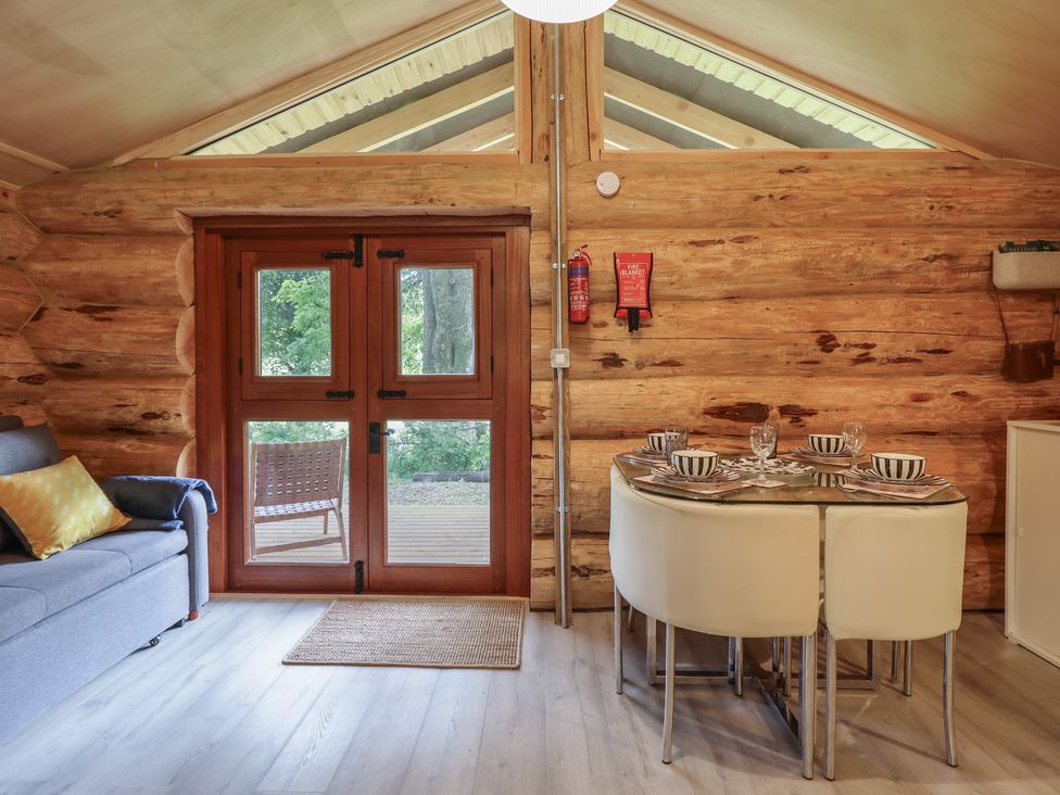 A dining area with a table and chairs at Owl Valley Cabin in Bwlch-y-Ddar near Llanfyllin