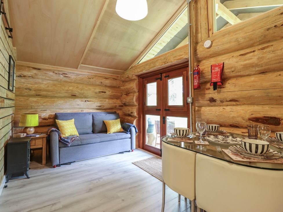 A living room with a couch and dining table at Owl Valley Cabin near Bwlch-y-Ddar near Llanfyllin