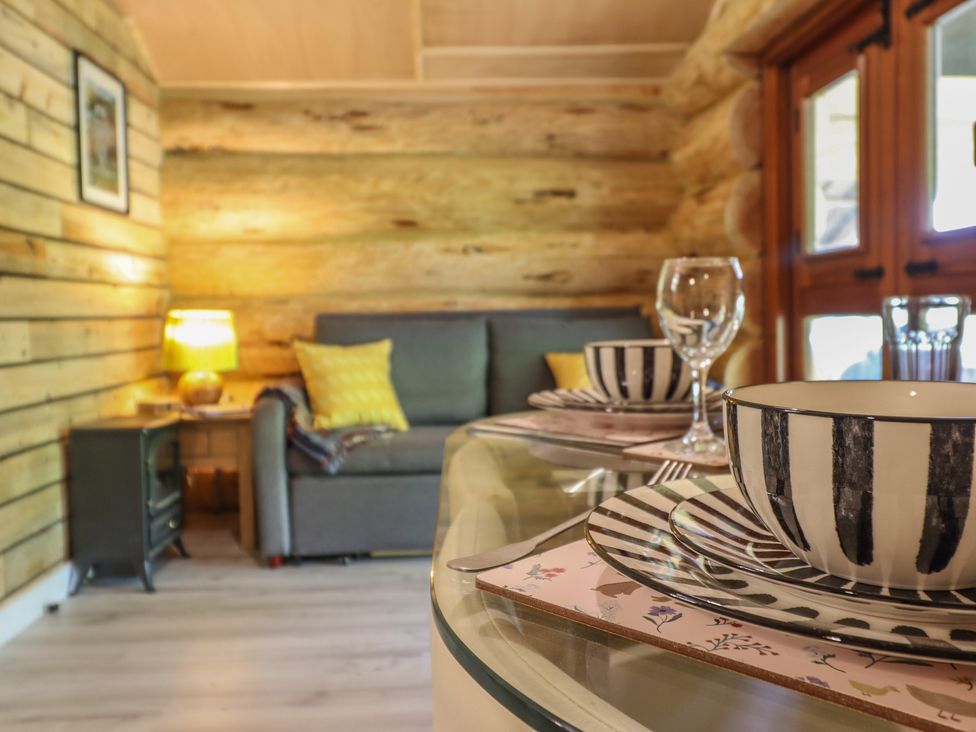 A living room with a sofa and dining table at Owl Valley Cabin near Bwlch-y-Ddar near Llanfyllin