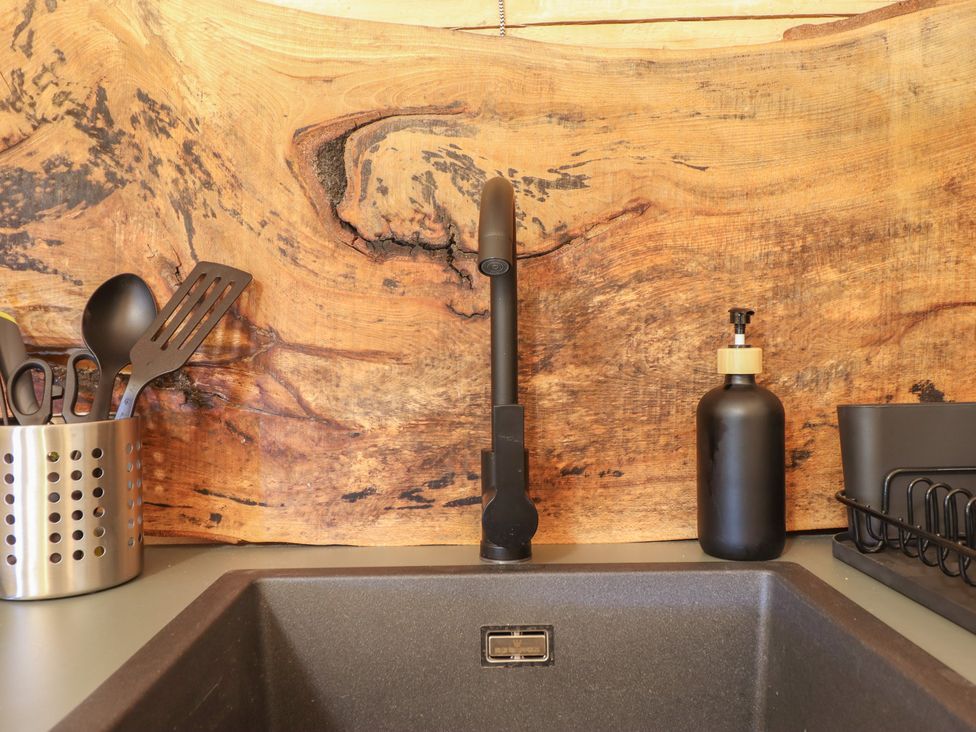A kitchen sink with faucet and utensils at Owl Valley Cabin Bwlch-y-Ddar near Llanfyllin