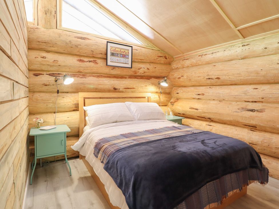 A bedroom with a bed and bedside table at Owl Valley Cabin, Bwlch-y-Ddar near Llanfyllin