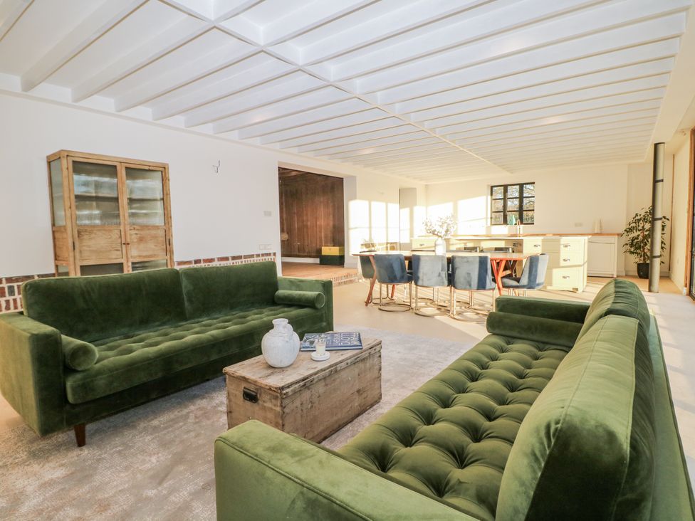 A living room with green sofas and a wooden table at Farm house
