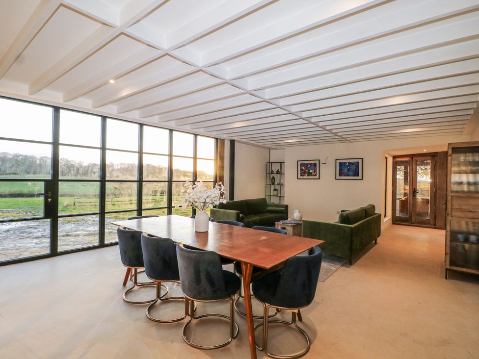 A living room with green sofas and a dining table at Farm house