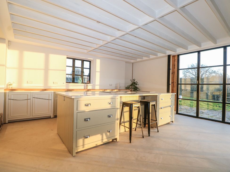 A kitchen with an island and stools at the Farm house