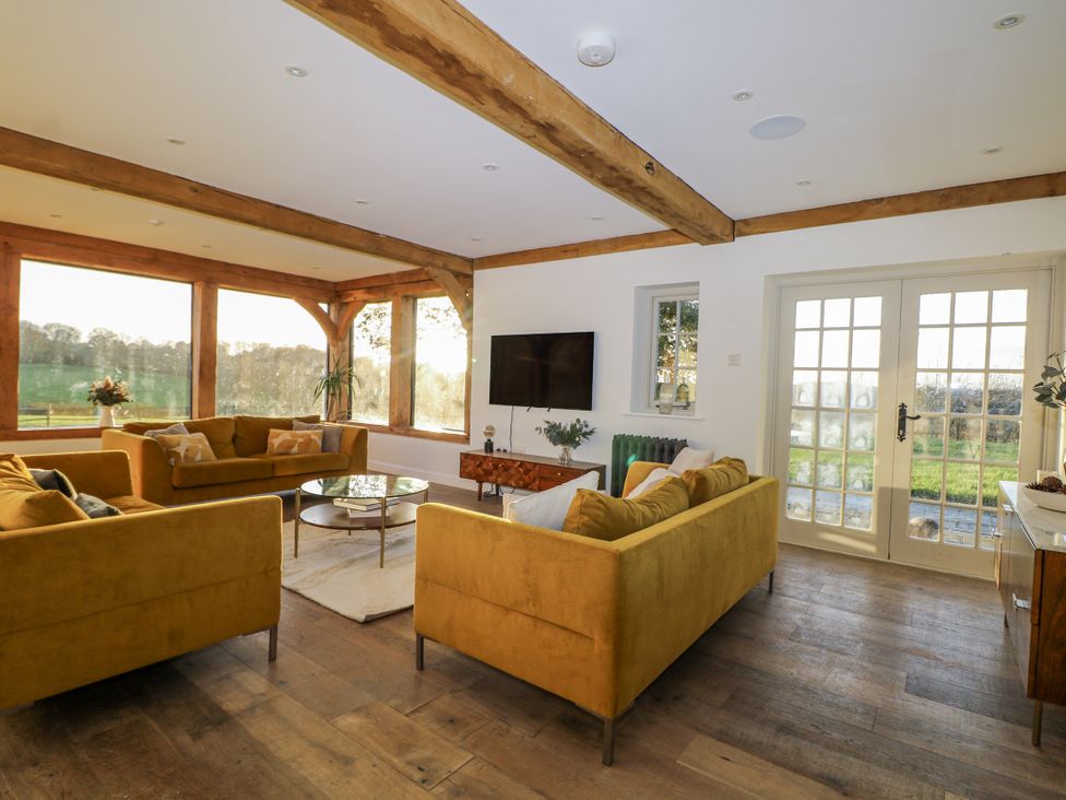 A living room with sofas and a television at Farm house