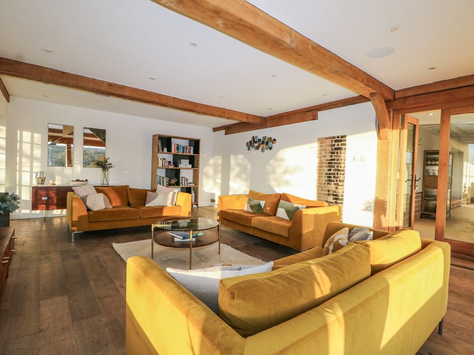 A living room with sofas, a coffee table and a bookshelf at Farm house