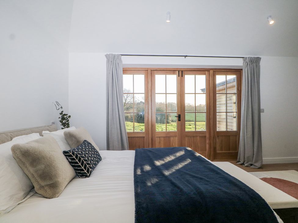 A bedroom with a bed and doors leading to the outdoor area at Farm house
