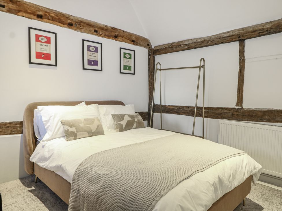 A bedroom with a bed and framed pictures at Farm house