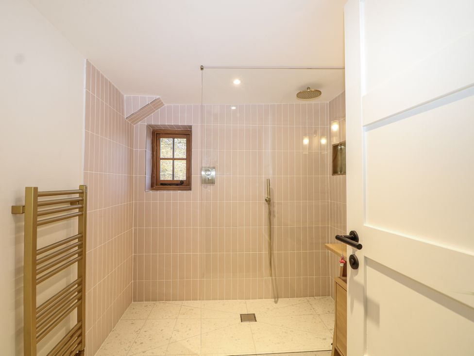 A bathroom featuring a shower, towel warmer, and window at Farm house in 