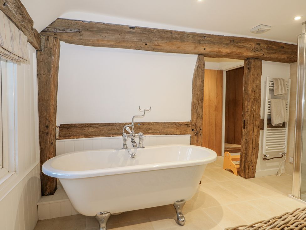 A bathroom featuring a bathtub and wooden beams at Farm house 