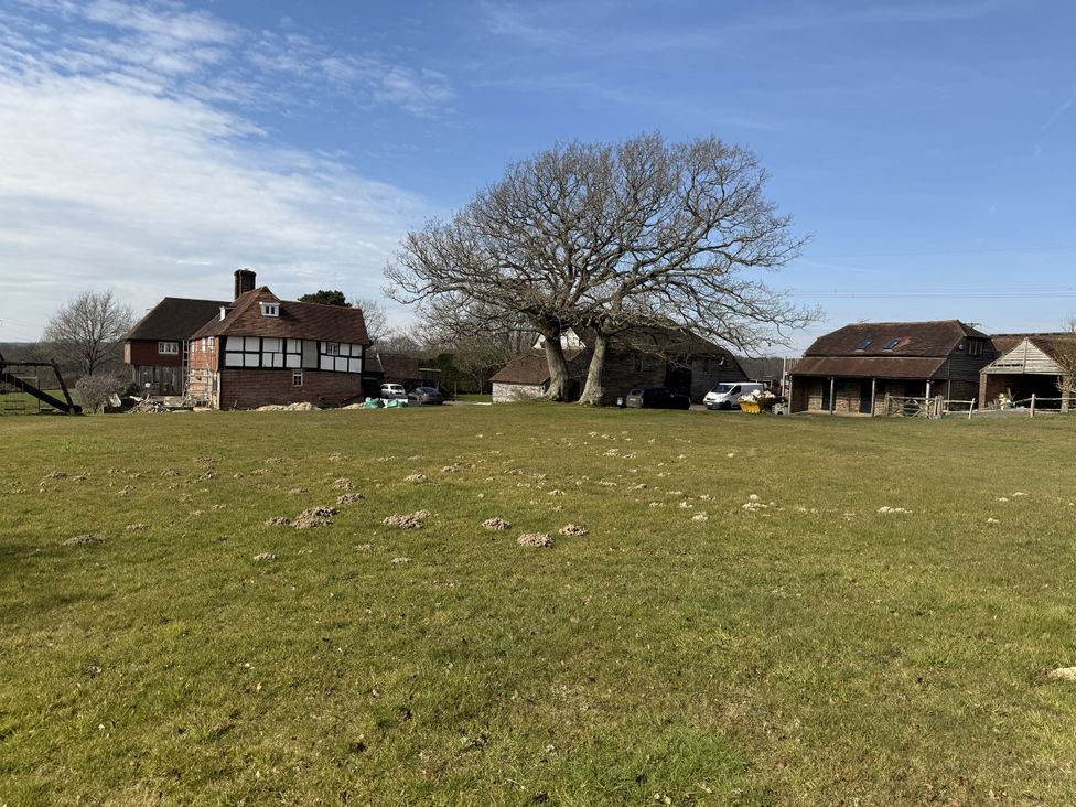 A farm area with a house, tree, and barn at Farm house in 