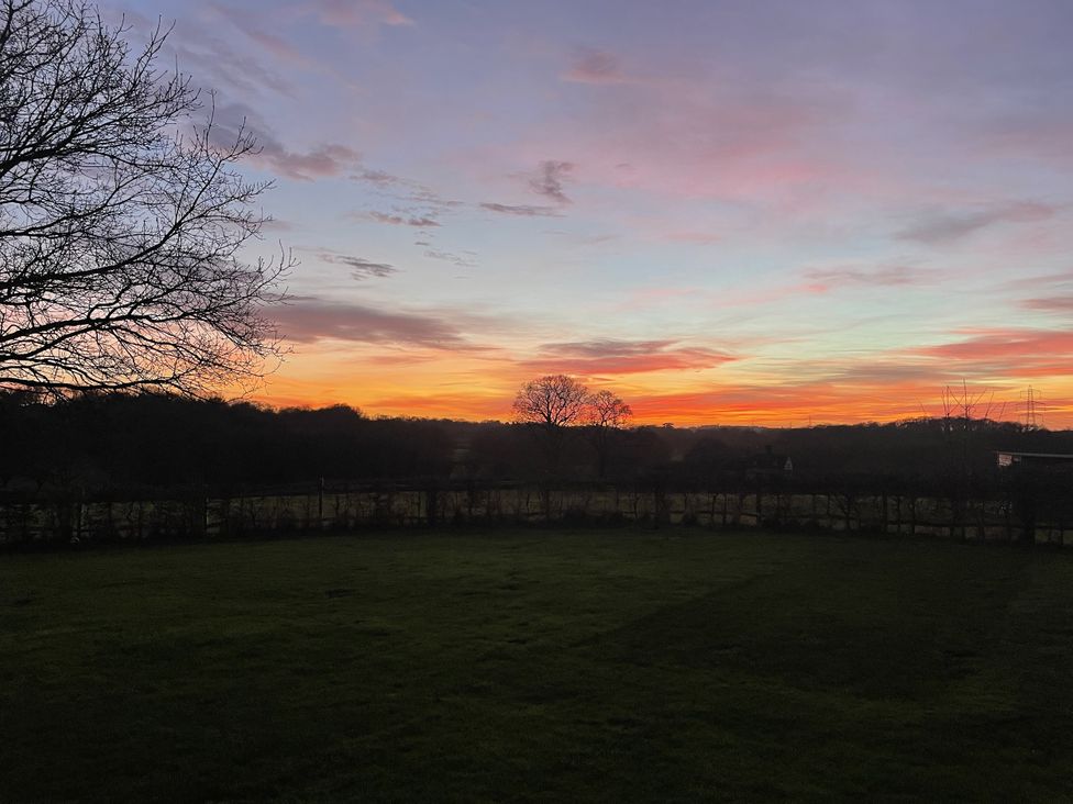 A tree and sunset view with a fence at the Farm house
