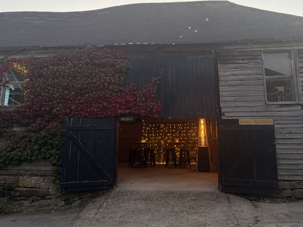 A barn entrance with lights and stools at Farm house North Chailey