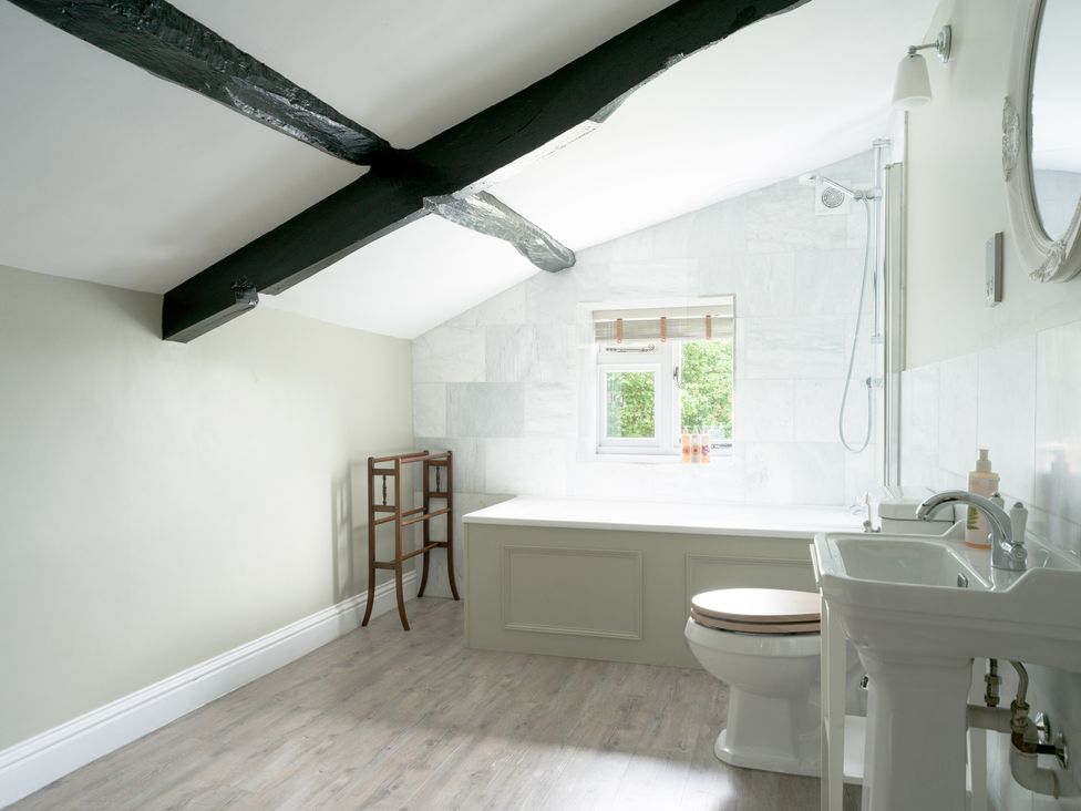 A bathroom with a bathtub and sink at Holwell Farmhouse in Bampton