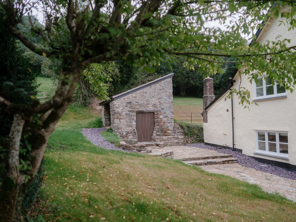 A stone building and patio area at Holwell Farmhouse in Bampton