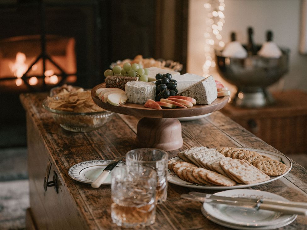 A dining table with cheese platter and drinks at Holwell Farmhouse in Bampton