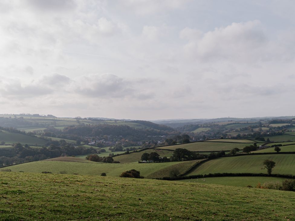 A landscape view of rolling hills and a village at Holwell Farmhouse in Bampton