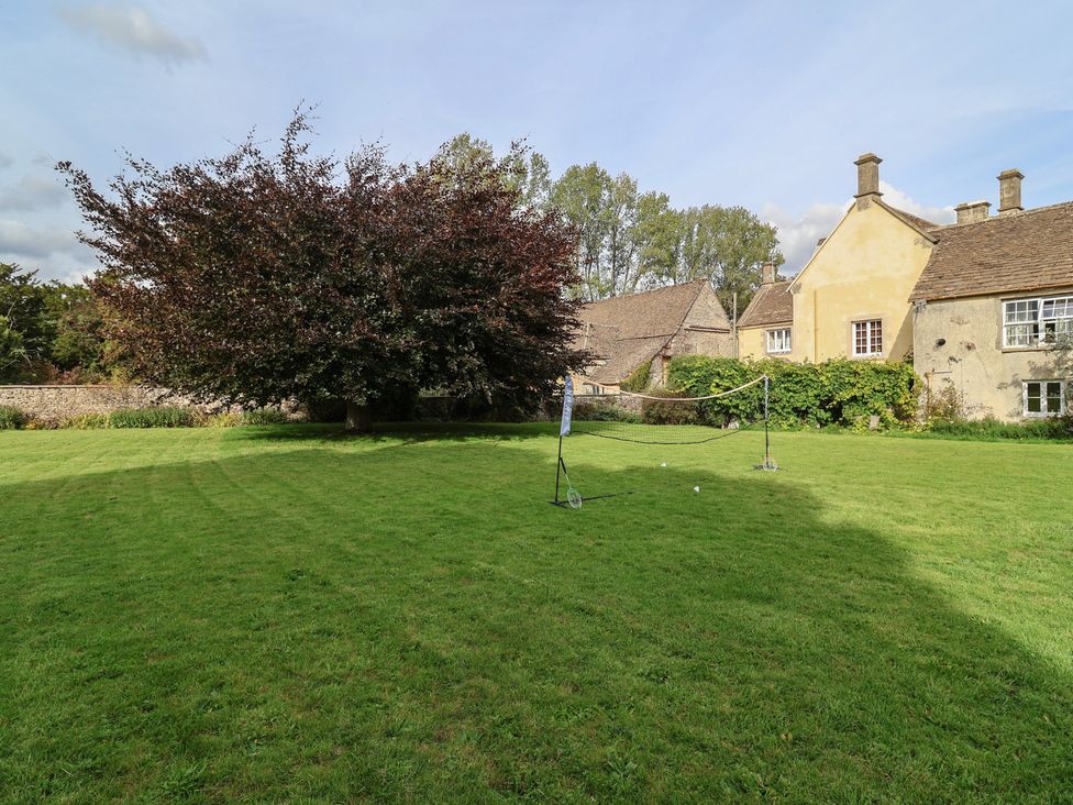 A garden with a tree and a net at Badminton Farm Cottage 