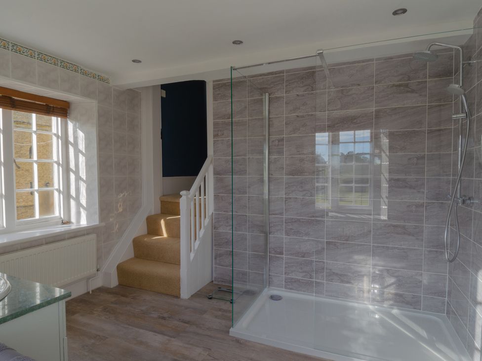 A bathroom with a shower and stairs at Badminton Farm Cottage Acton Turville