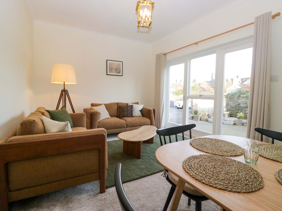 A living room with a sofa and dining table at 11 Tram Lane in Kirkby Lonsdale